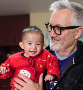 Tim Baker holding Chinese orphan boy