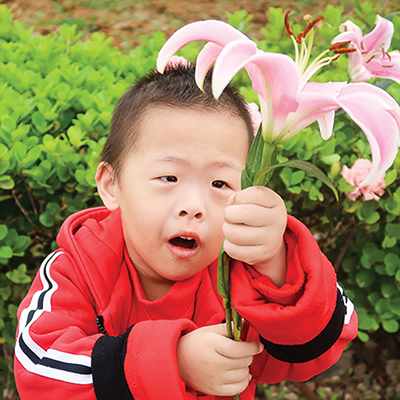 child at healing home holding a flower